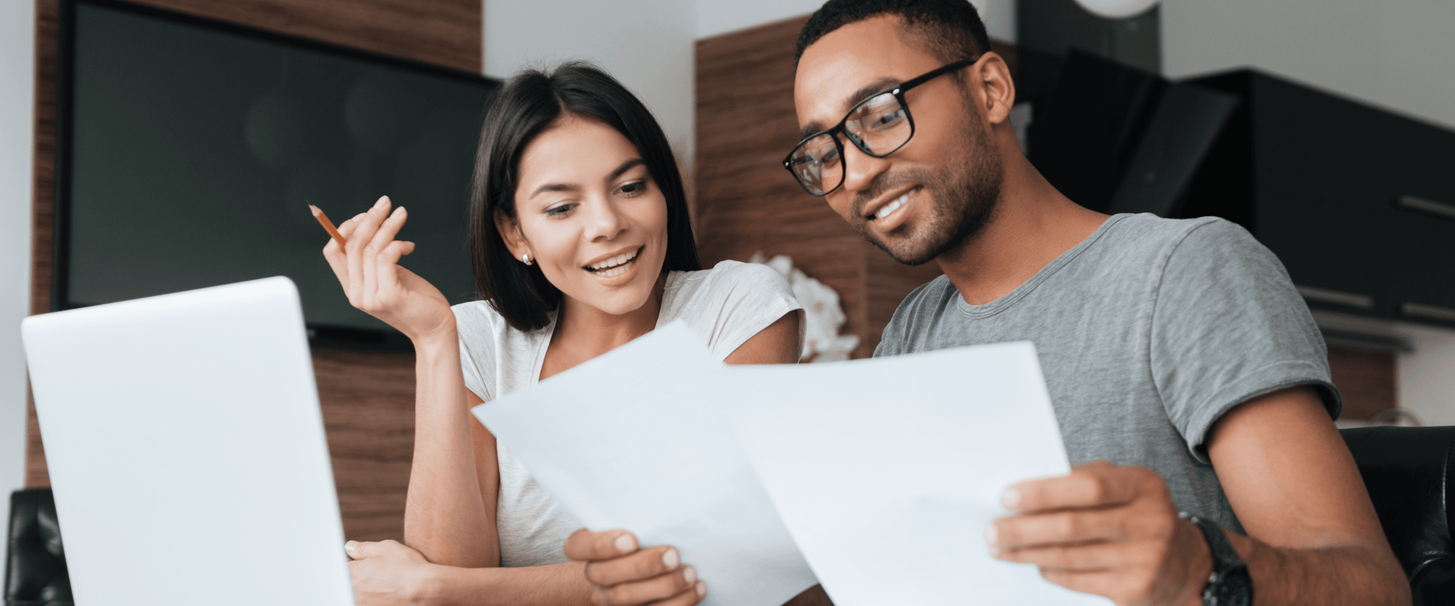 Couple at a laptop reviewing student loan statements together and checking their credit
