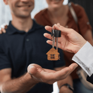 a couple being handed keys to their new house